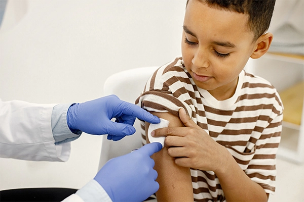 Child vaccination at home in Barcelona with healthcare professional applying post-vaccine care